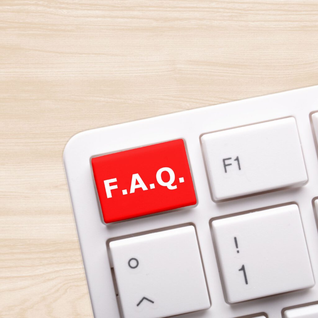 Weiße Computertastatur mit einer roten Taste, auf der in weißen Großbuchstaben „F.A.Q.“ steht. Symbolisch für häufig gestellte Fragen oder einen FAQ-Bereich auf einer Website.